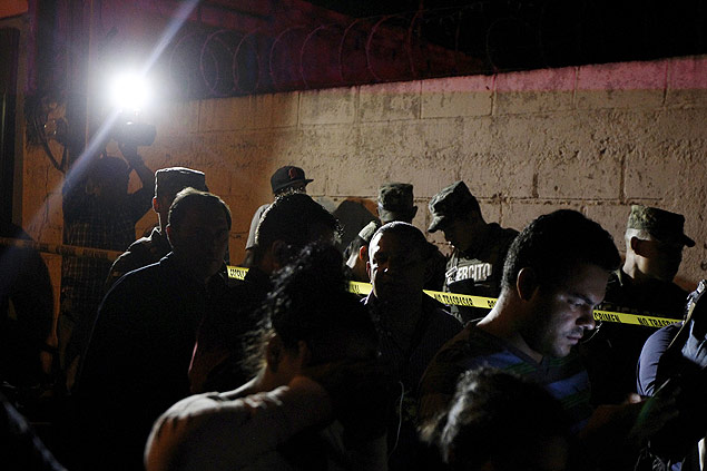 Jornalistas e policiais em frente a local onde oito homens foram mortos por gangue de Tegucigalpa