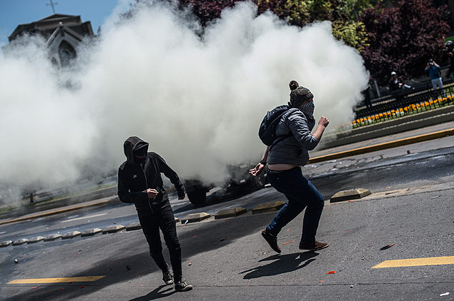 Manifestantes fogem de bombas de gs lacrimogneo atiradas pela polcia durante protesto em Santiago 