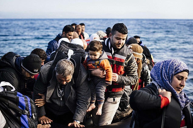 Refugees and migrants arrive on a dinghy, on the Greek island of Lesbos, after crossing the Aegean sea from Turkey, on October 17, 2015. Twelve migrants drowned when their boat sank off the Turkish coast as they were seeking to reach Greece, while around 25 others were rescued, the Anatolia news agency reported. AFP PHOTO / DIMITAR DILKOFF ORG XMIT: DIM006
