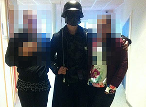 This picture made available to AFP by a student shows the masked man armed with a sword posing for a photo with two other students before attacking students and staff at the primary and middle school in Trollhattan, southwestern Sweden, on October 22, 2015. The man brandishing a sword broke into a school in Sweden, killing two people and seriously wounding two others before being shot by police. AFP PHOTO +++ RESTRICTED TO EDITORIAL USE ORG XMIT: 6212