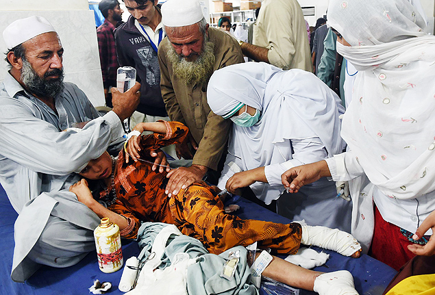 Pakistani paramedics treat a girl injured in an earthquake at a hospital in Peshawar on October 26, 2015. At least 17 people including eight children were killed in Pakistan when a 7.5 magnitude quake struck in Afghanistan October 26, officials said. AFP PHOTO / A MAJEED ORG XMIT: AQ1129