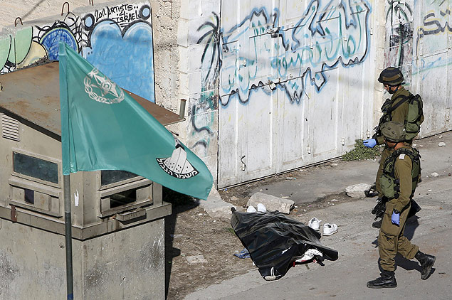 Soldados de Israel cercam o corpo de um palestino que tentou atacar as foras com uma faca em Hebron