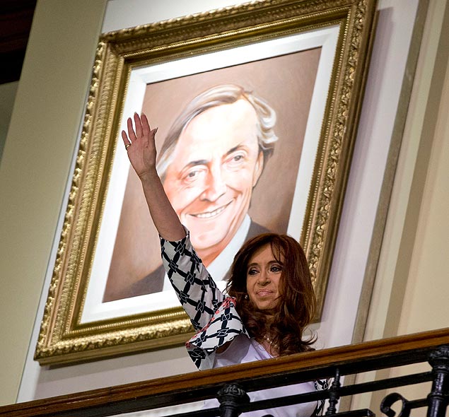 Argentina's President Cristina Fernandez waves at the government house in front of a painting of her late husband Nestor Kirchner in Buenos Aires, Argentina, Thursday, Oct. 29, 2015. Fernandez's chosen successor, presidential candidate Daniel Scioli, will face opposition candidate Mauricio Macri in a presidential runoff election on Nov. 22. (AP Photo/Natacha Pisarenko) ORG XMIT: XNP106
