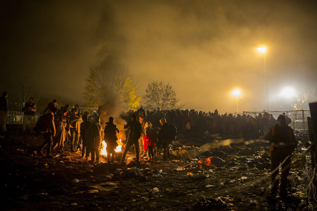 Pessoas fazem fogueira para se aquecer em campo de refugiados em Spielfed, na ustria