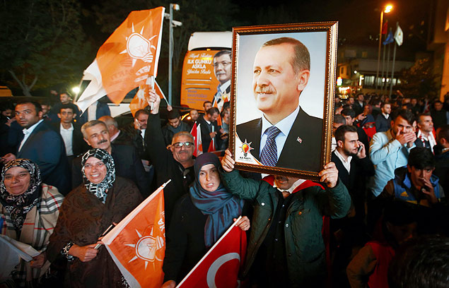 People wave flags and hold a portrait of Turkish President Tayyip Erdogan outside the AK Party headquarters in Istanbul, Turkey November 1, 2015. Turks went to the polls in a snap parliamentary election on Sunday under the shadow of mounting internal bloodshed and economic worries, a vote that could determine the trajectory of the polarised country and of President Tayyip Erdogan. The vote is the second in five months, after the AK Party founded by Erdogan lost in June the single-party governing majority it has enjoyed since first coming to power in 2002. REUTERS/Osman Orsal ORG XMIT: CVI11135