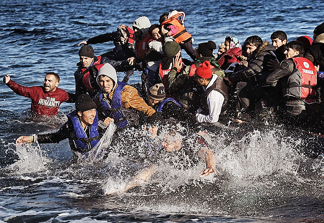 Migrantes chegam  ilha grega de Lesbos, aps atravessarem o mar Egeu em barco superlotado