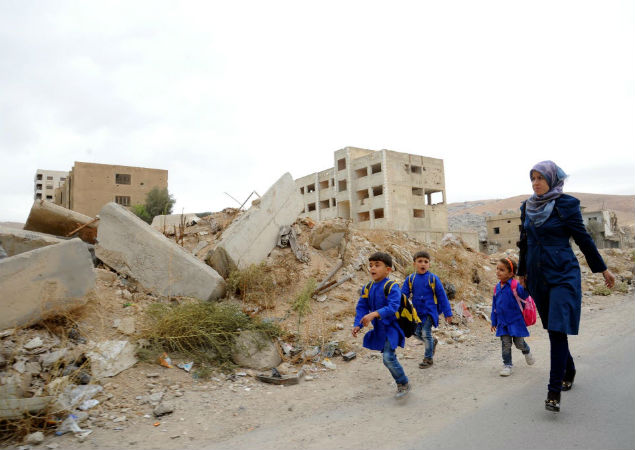  Estudantes srios se dirigem  escola em meio a escombros no distrito de Barzeh, em Damasco (jp) (ah)