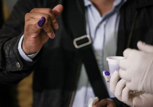 Funcionrio do Conselho Nacional Eleitoral faz prova com tinta indelvel que ser usada nas eleies