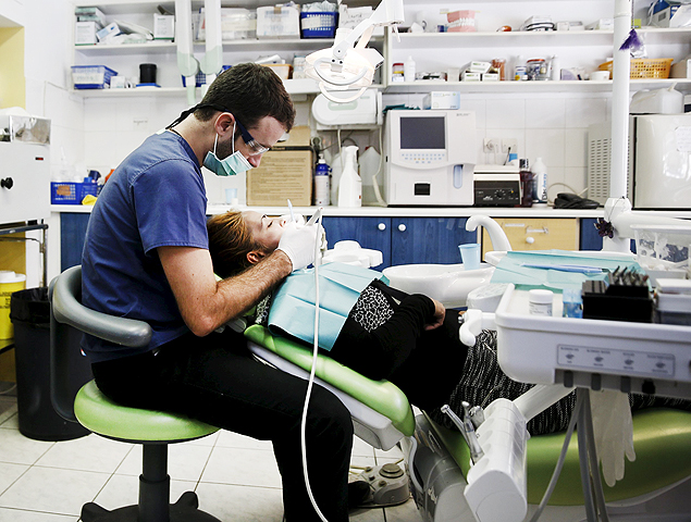 Dentist Christos Naoumis treats a patient at the Doctors of the World polyclinic in central Athens, Greece, October 27, 2015. Picture taken October 27, 2015. To match Special Report GREECE-TEETH/ REUTERS/Alkis Konstantinidis ORG XMIT: PXP402