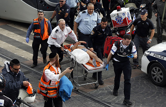 Israeli paramedics and security forces evacuate a wounded Palestinian boy, who was shot after allegedly stabbing an Israeli security guard, at a tramway station in the settler neighbourhood of Pisgat Zeev in annexed east Jerusalem on November 10, 2015. Two knife-wielding Palestinian boys aged 12 to 13 attacked a security guard in the settler neighbourhood, with one shot and wounded and the other arrested, police said. The security guard was wounded and treated at the scene, police spokeswoman Luba Samri said. AFP PHOTO / AHMAD GHARABLI ORG XMIT: XAG708