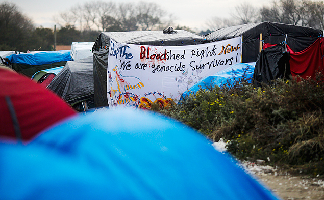 In this Tuesday, Nov. 3, 2015 photo a banner with a statement is fixed between tents inside France’s biggest refugee camp near Calais, northern France. Improvised clinics have appeared from nowhere in the Calais’ migrant camp, where medical care for an estimated 6,000 souls depends on volunteers from several countries. (AP Photo/Markus Schreiber) ORG XMIT: MCC105
