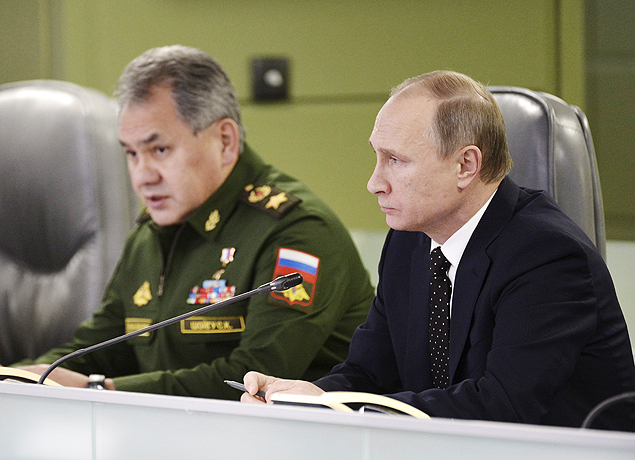 O presidente Vladimir Putin e seu ministro da Defesa, Serguei Shoigu (esq.), falam sobre ataques  Sria 