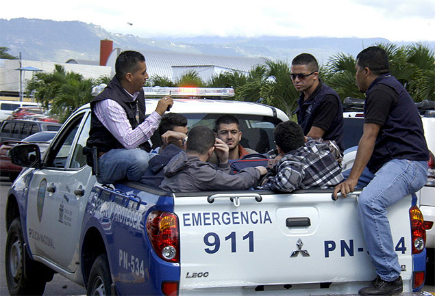 Policiais hondurenhos transportam cinco migrantes srios detidos no aeroporto de Tegucigalpa