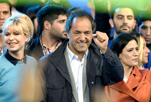 Buenos Aires province governor and presidential candidate for the "Frente para la Victoria" (Front for Victory), Daniel Scioli (C) and his wife Karina Rabolini (L) attend the closing rally of his campaign in La Matanza, Buenos Aires province, on November 19, 2015. Argentina's presidential election is headed for a November 22 runoff between incumbent Cristina Kirchner's chosen successor Daniel Scioli and conservative rival Mauricio Macri. AFP PHOTO/Eitan Abramovich ORG XMIT: ESS577