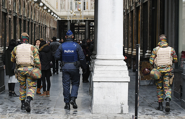 Belgian soldiers and police officers patrol at the entrance of the Galerie de la Reine near the Grand Place in Brussels on November 22, 2015. The Belgian capital was locked down for a second day on November 22 with police and troops on the streets as the authorities hunted for several suspects linked to the Paris attacks. Belgian officials were due to meet later to decide whether to extend the security alert in Brussels, imposed over fears jihadists were plotting similar strikes to the attacks in Paris which left 130 people dead on November 13. AFP PHOTO / JOHN THYS ORG XMIT: THY19