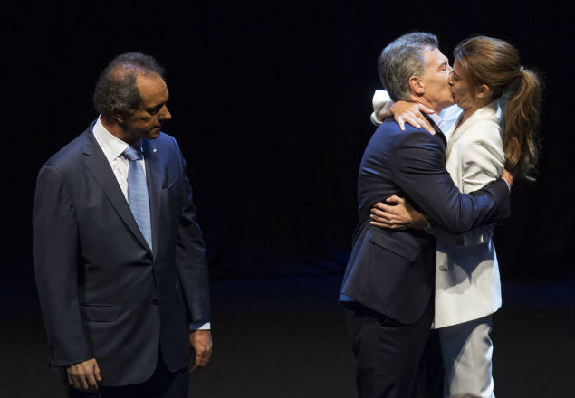 Observado por Scioli, Mauricio Macri beija sua mulher, Juliana Awada, ao final do debate do dia 15