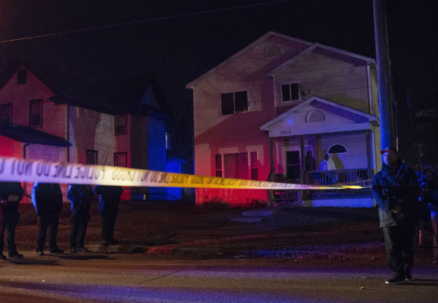 MINNEAPOLIS, MN - NOVEMBER 24: Police line up in front of a crime scene, and two people look on from their porch after 5 people were shot at a Black Lives Matters protest November 24, 2015 in Minneapolis, Minnesota. According to reports, a group of white men allegedly opened fire on the crowd after being escorted away from the encampment. Stephen Maturen/Getty Images/AFP == FOR NEWSPAPERS, INTERNET, TELCOS & TELEVISION USE ONLY ==