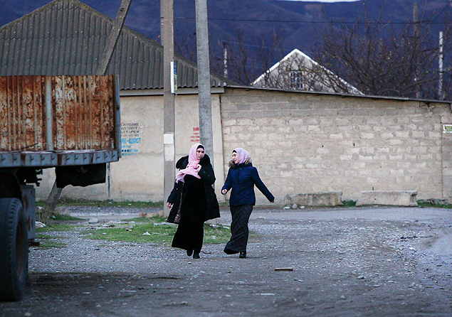 In this photo taken Thursday, Nov. 12, 2015, local residents walk in a street in the village of Komsomolskoye, Dagestan, Russia. An epidemic of recruitment for the Islamic State group has swept through the predominantly Muslim Dagestan where young men and women are leaving for Syria, pursuing a religious ideal or trying to escape police profiling. (AP Photo/Sergei Grits) ORG XMIT: MOSB511