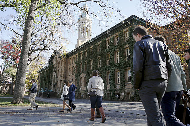 Estudantes caminham em frente ao Nassau Hall, na Universidade de Princeton, Estados Unidos
