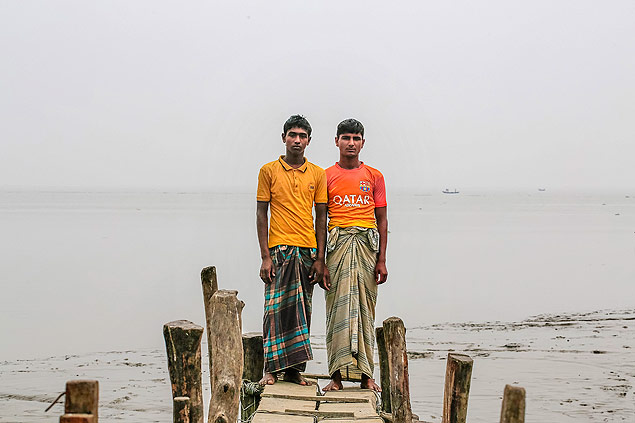 Os irmos Ashikur e Arifur posam em frente  ponte que dava acesso a sua casa em Bhola, Bangladesh