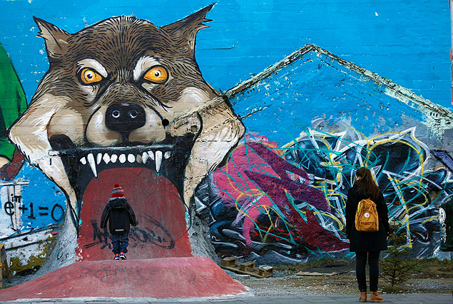 Mulher e criana caminham em frente a grafite em Reykjavk; islandeses fazem protesto com 'zusmo'