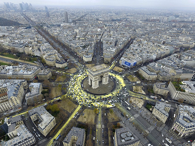 Ativistas do Greenpeace pintam de amarelo as ruas perto do Arco do Triunfo, para tentar simbolizar o Sol