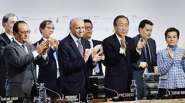 O presidente da França, Francois Hollande, o chanceller francês, Laurent Fabius, e o secretário-geral da ONUBan Ki-moon aplaudem após proposta de acordo para a COP21