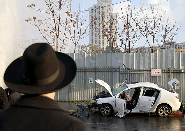 Israelense observa o carro de Abdel Muhsan Hasuna, morto após atropelar 11 em um ponto de ônibus 