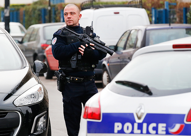 A police officer patrols near a pre-school, after a masked assailant with a box-cutter and scissors who mentioned the Islamic State group attacked a teacher, Monday, Dec.14, 2015 in Paris suburb Aubervilliers. The assailant remains at large, and the motive for the attack is unclear, authorities said. (AP Photo/Michel Euler) ORG XMIT: PAR110