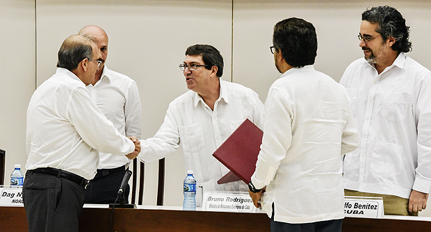 The head of the Colombian government delegation to the peace talks with the FARC-EP leftist guerrillas, Humberto de la Calle (L) and Cuban Foreign Minister Bruno Rodriguez (2nd-L) shake hands after the signing of the agreement on the victims of the conflict at Convention Palace in Havana, on December 15, 2015. AFP PHOTO/ADALBERTO ROQUE ORG XMIT: HAV04