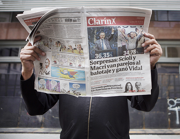 Morador de Buenos Aires lê exemplar do jornal "Clarín" em 2015; conglomerado de mídia cresce na Argentina 