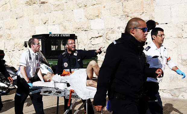 Israeli paramedics evacuate a Palestinian assailant who was shot an wounded by Israeli polcie following a reported stabbing attack next to Jerusalems Old City Jaffa Gate on December 23, 2015. Two Palestinians stabbed three Israelis near Jerusalem's Old City before police shot them, killing one attacker and wounding the other, police said. Israel's Magen David Adom emergency medical service said the three victims were taken to hospitals in Jerusalem in serious condition. AFP PHOTO / GALI TIBBON ORG XMIT: AG40