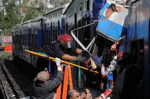 Equipe de bombeiros resgatam passageiro do trem que colidiu com a plataforma na estao de trem de Once, em Buenos Aires