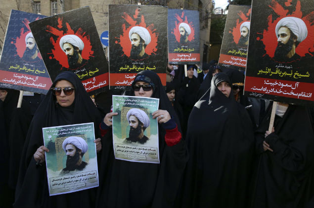 Manifestantes iranianos seguram cartazes com a foto do clrigo Nimr al-Nimr em protesto diante da Embaixada da Arbia Saudita, em Teer 