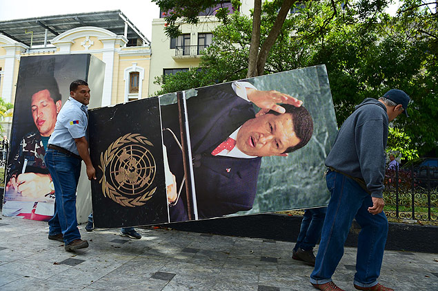 National Assembly employees remove from the building pictures of late President Hugo Chavez, in Caracas on January 6, 2016. Venezuela's opposition on Tuesday broke the government's 17-year grip on the legislature and vowed to force out President Nicolas Maduro despite failing for the time being to clinch its hoped-for "supermajority." AFP PHOTO/RONALDO SCHEMIDT ORG XMIT: RON017