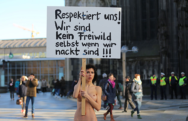 A artista Milo Moire carrega cartaz em que pede respeito s mulheres em protesto em Colnia