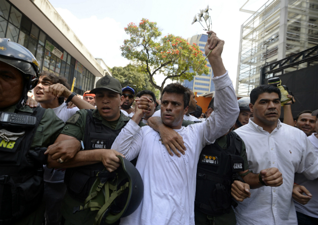 Leopoldo Lopez (C), ardent opponent of Venezuela's socialist government, is escorted by the National Guard after turning himself in, during a demonstration in Caracas on February 18, 2014. Jailed Venezuelan opposition leader Leopoldo Lopez was sentenced to 13 years, nine months and seven days in prison, his lawyer Roberto Marrero said late September 10, 2015. The popular dissident, a US-trained economist who has been held at a military prison since February 2014, is accused of inciting violence against the government of President Nicolas Maduro and attempting to force his ouster. 