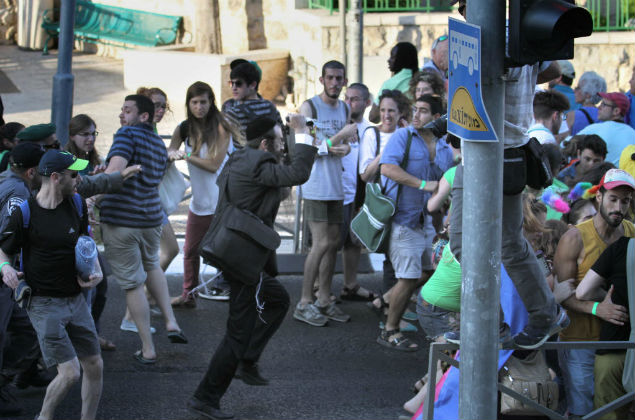 UNCROPPED VERSION Yishai Shlissel (C), an ultra-orthodox Jew, raises a knife as he unleashed on an attack stabbing six people taking part in a Gay Pride parade in central Jerusalem on July 30, 2015, seriously wounding two, Israeli police and health services said. Shlissel was released from jail three weeks ago after having served his sentence for a similar attack a decade ago when three marchers were wounded, a police spokesman said. AFP PHOTO / KOBI ORG XMIT: MK4297