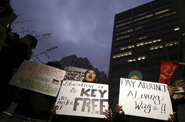  hold up signs and chant slogans as they attend a demonstration calling for lower tuition at Hunter College in the Manhattan borough of New York November 12, 2015. Students held rallies on college campuses across the United States on Thursday to protest ballooning student loan debt for higher education and rally for tuition-free public colleges and a minimum wage hike for campus workers. REUTERS/Carlo Allegri ORG XMIT: NYC103
