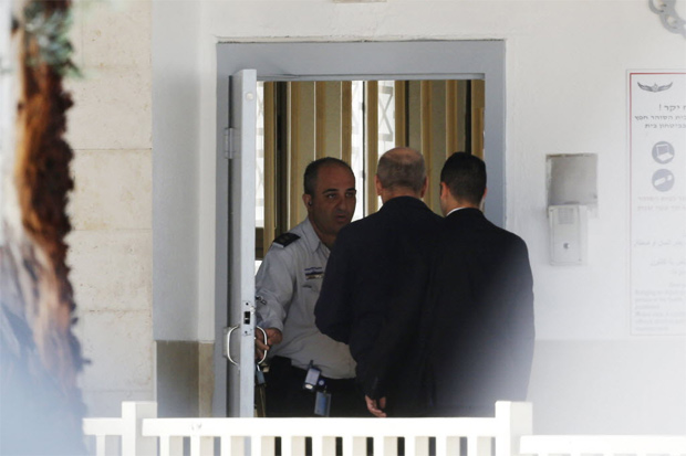 Ex-premi israelense Ehud Olmert (centro) entra na priso de Maasiyahu, ao sul de Tel Aviv, onde cumprir pena