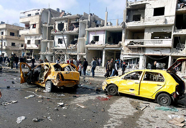 Foto da agência síria Sana mostra bairro de Homs após série de ataques neste domingo (21) 