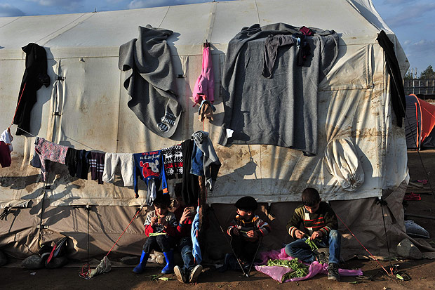 Refugiados esperam para cruzar a fronteira da Grcia com a Macednia perto da vila de Idomeni