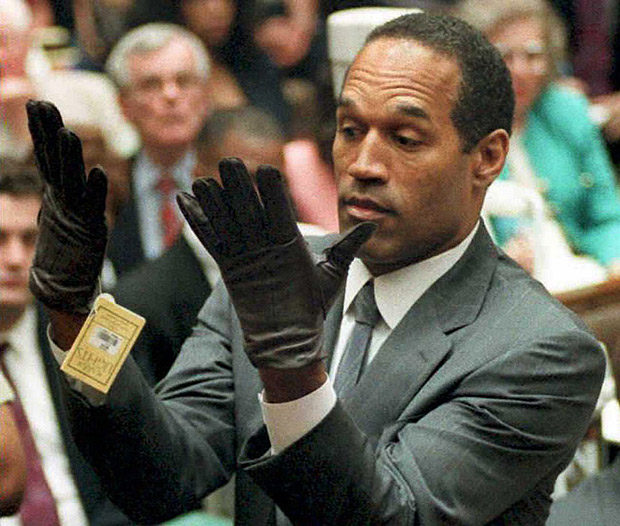 (FILES) This file photo taken on November 30, 1995 shows former US football player and actor O.J. Simpson looking at a new pair of Aris extra-large gloves that prosecutors had him put on during his double-murder trial in Los Angeles. Twenty years ago, it was the 