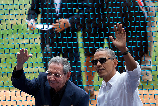O presidente dos EUA, Barack Obama, acena ao lado do ditador Ral Castro em estdio de Havana