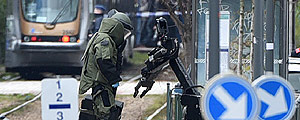 Agente do esquadrão de bomba analisa objeto suspeito em estação de trem – Patrik Stollarz/AFP