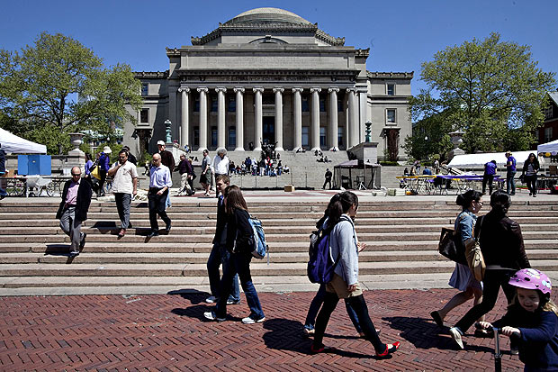 Estudantes e pedestres andam em frente da Biblioteca Memorial da Universidade Columbia