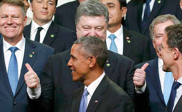 Presidente ucraniano, Petro Poroshenko, faz duplo sinal positivo atrs de Obama em foto de cpula