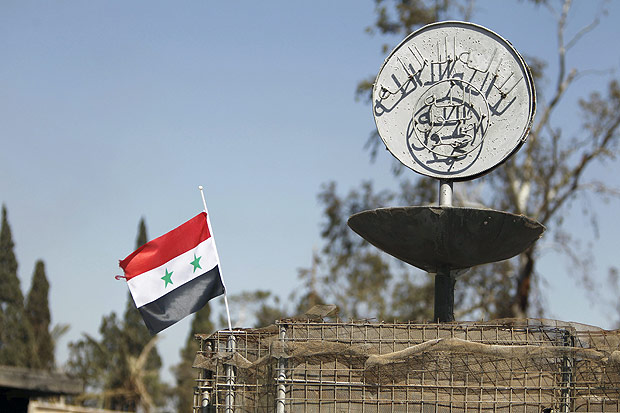 Bandeira sria aparece ao lado de slogan do Estado Islmico em Palmira, retomada pelo regime