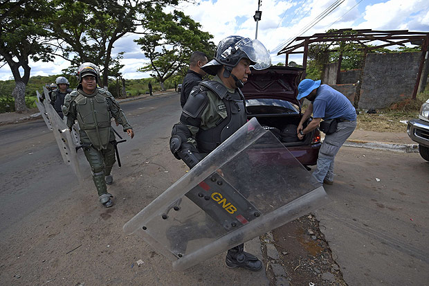 Military police officers patrol the streets of Tumeremo, Bolivar state, Venezuela on March 11, 2016. Twenty-eight miners failed to return home from work after their shifts on March 3, and stories soon began circulating that a group of gunmen had attacked the goldmine in southeastern Venezuela where they worked. AFP PHOTO / JUAN BARRETO ORG XMIT: VEN588