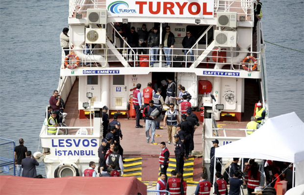 Imigrantes deportados da ilha de Lesbos, na Grécia chegam de barco à cidade de Dikili em 8 de abril